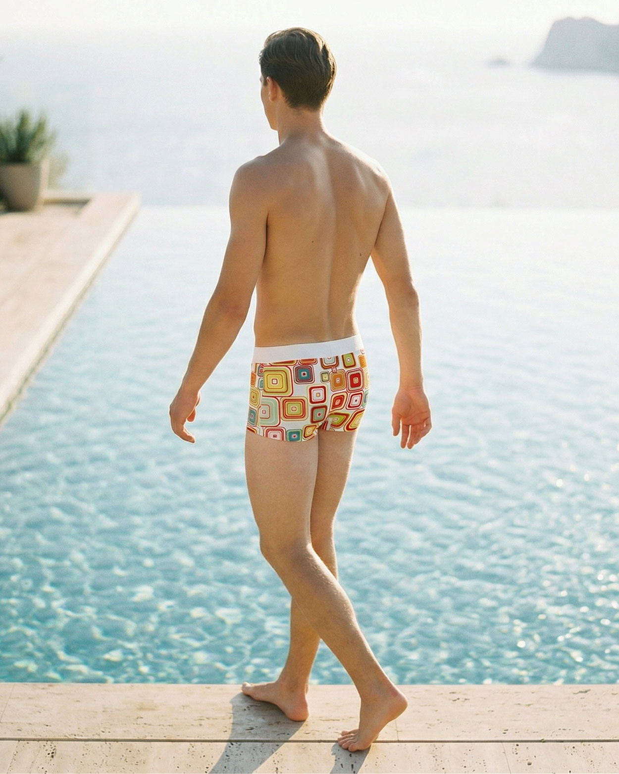 homme marchant sur le bord de piscine en boxer moulant