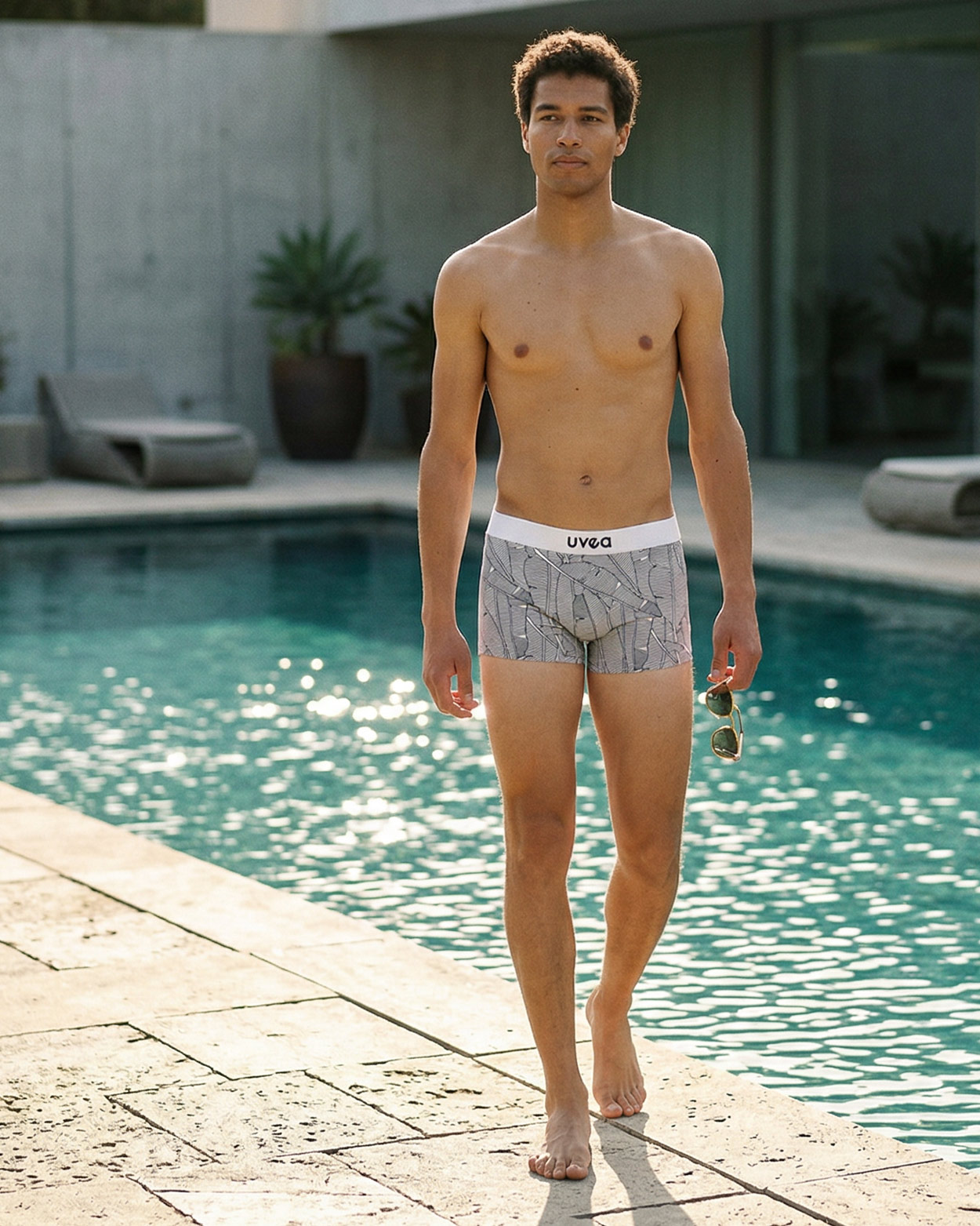 homme marchant en boxer de bain sur le bord d'une piscine