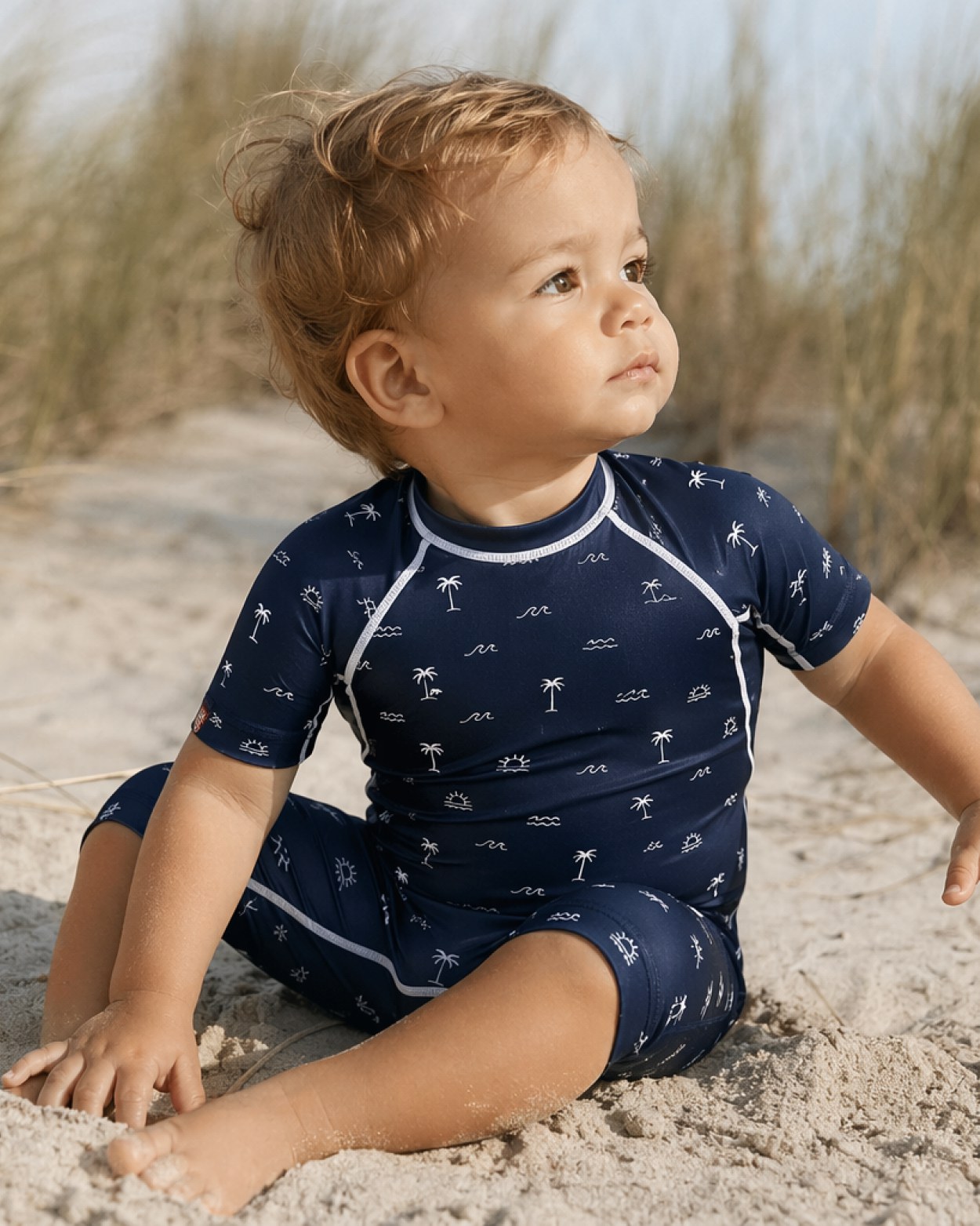 Bébé en combinaison anti-UV UVEA à la plage