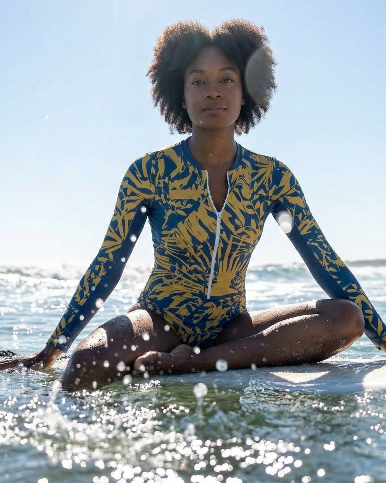 femme en combinaison uv assise sur un surf