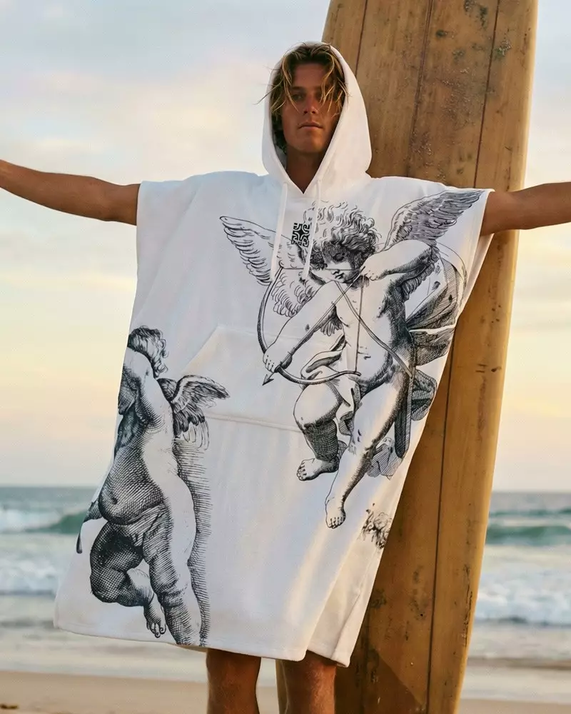 homme en poncho sur une plage 