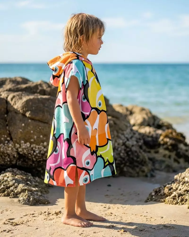 enfant en poncho sur une plage 