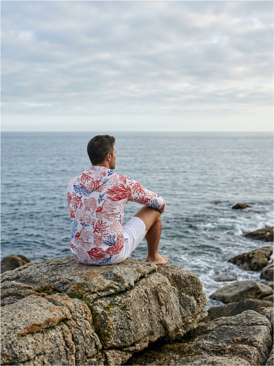 homme assi sur un rocher avec un rashguard