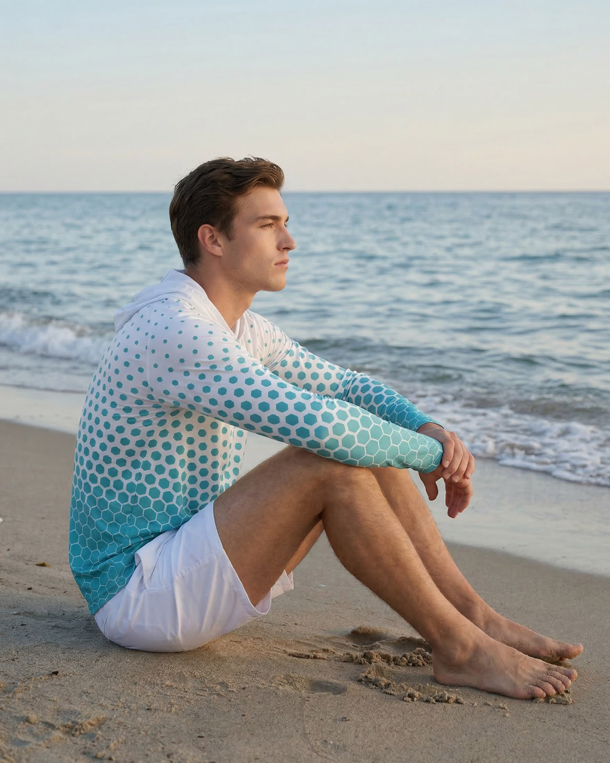 homme assi sur un rocher avec un rashguard 