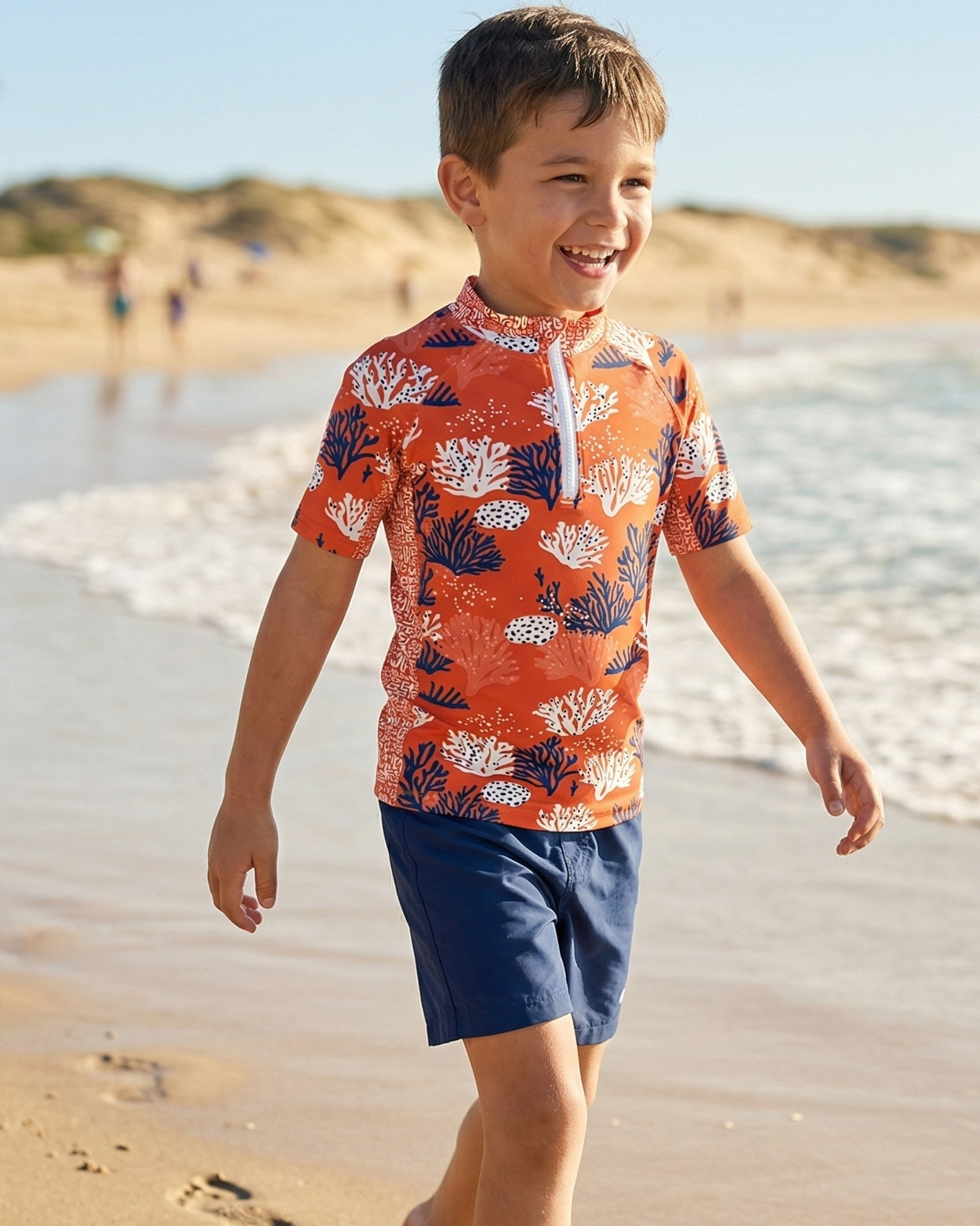 garçon en teeshirt uv jouant sur le sable