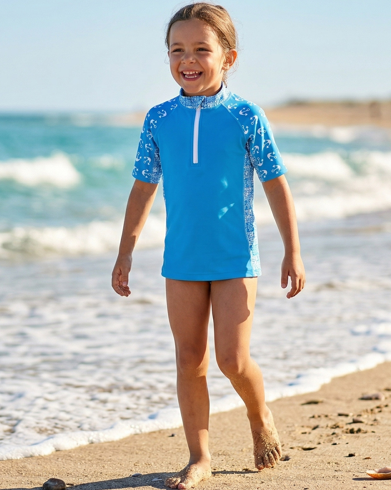 fille en teeshirt uv jouant sur le sable