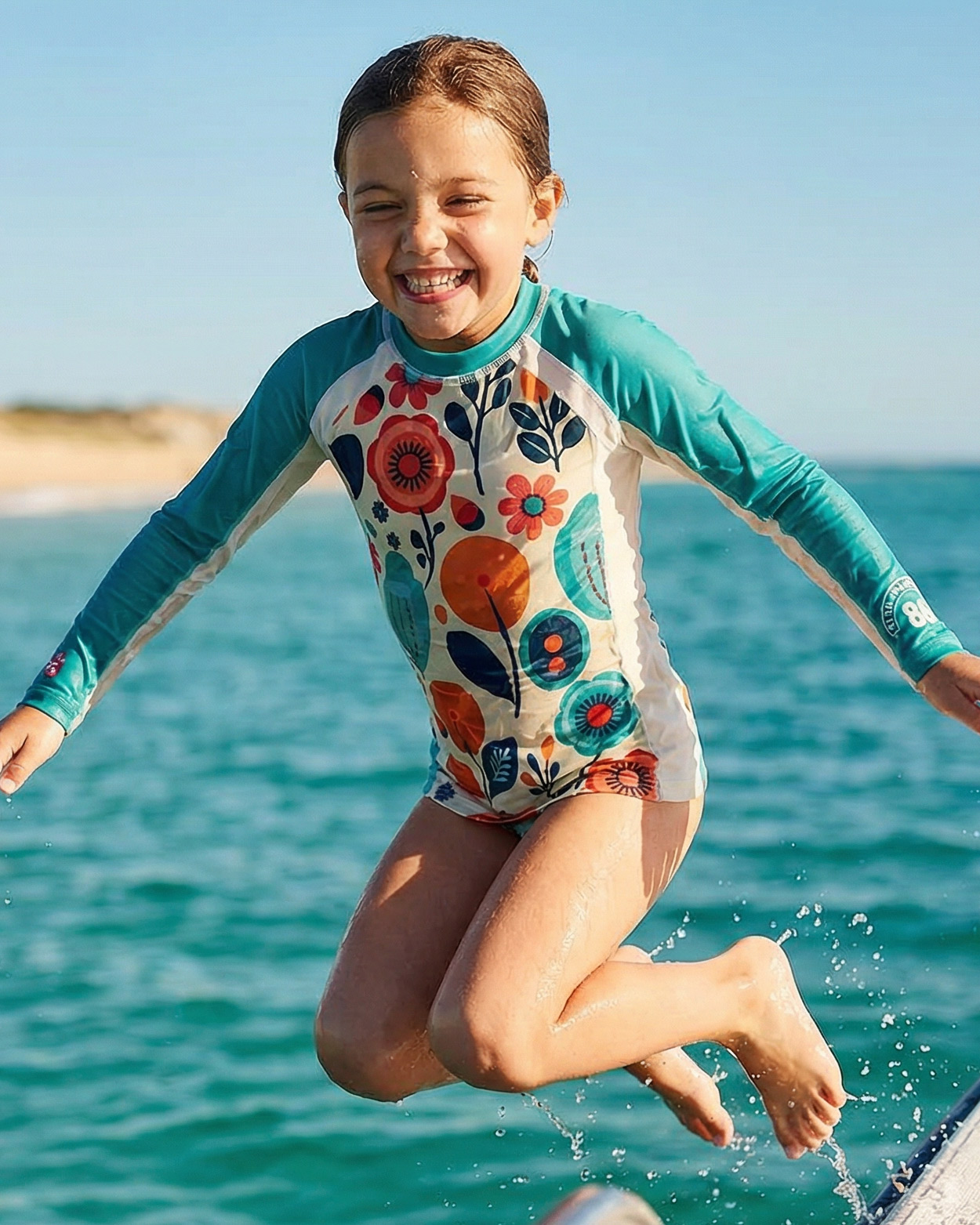 fille en teeshirt uv sautant dans l'eau