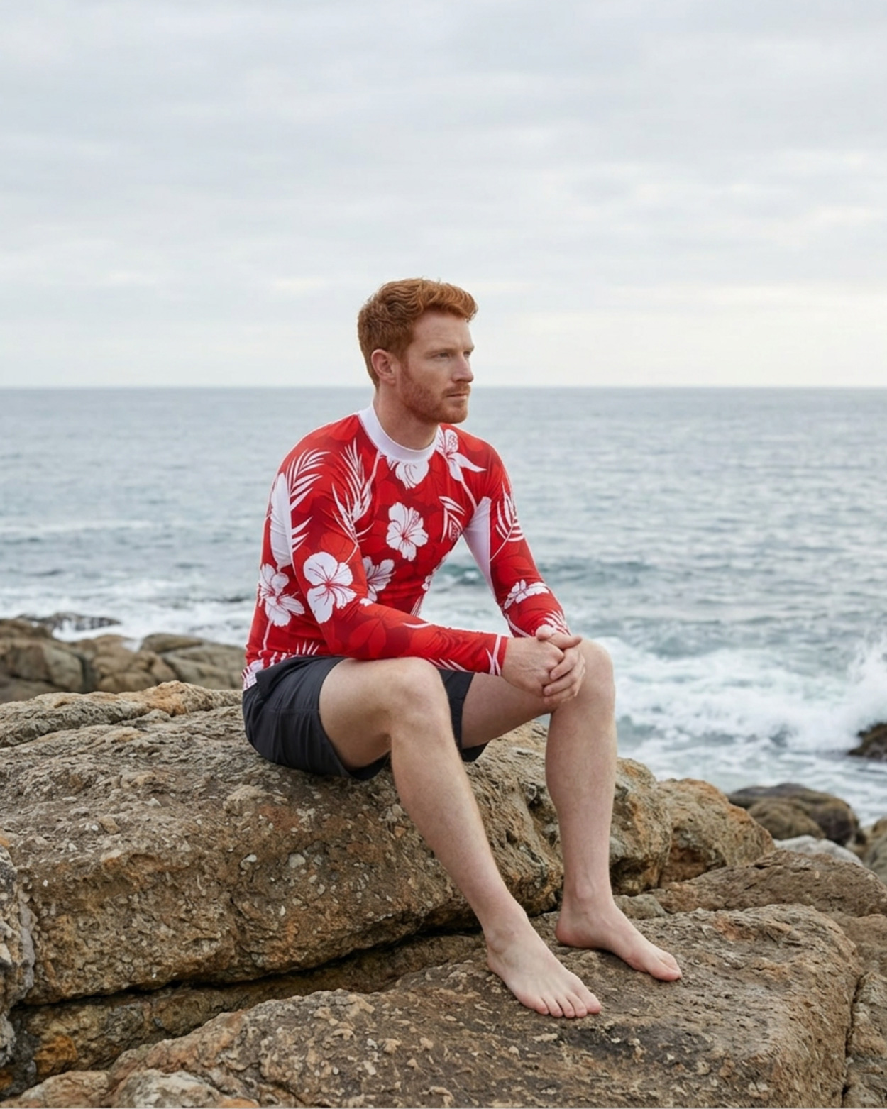 homme portant un tee shirt anti uv rouge sur un rocher