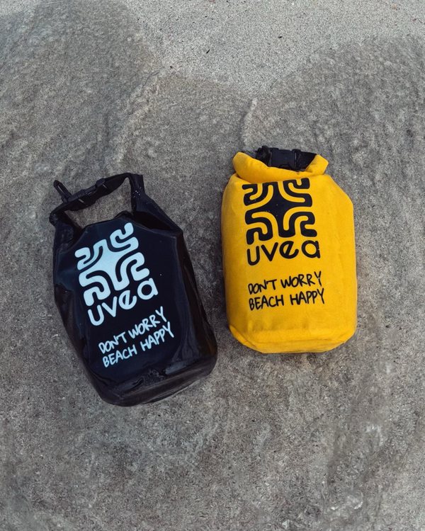 Schwarzer und gelber UVEA Dry Bag auf einem Felsen